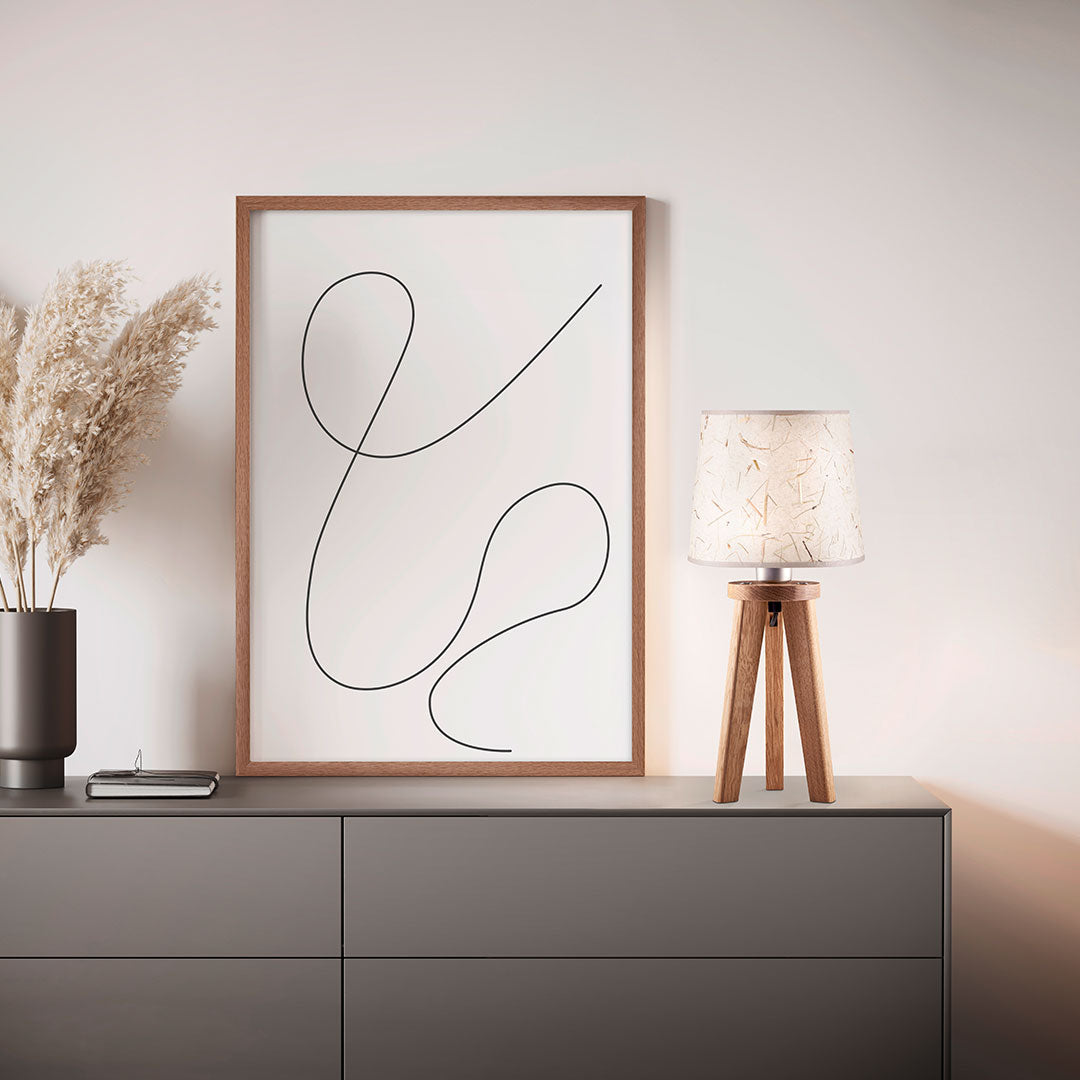 Dreibein Tischleuchte Naturart aus Asteiche geölt, Modell Elli, Schirm Almwiesenheu, Kabel im Bein verlaufend, Milieubild im Wohnzimmer, Leuchte steht auf Kommode