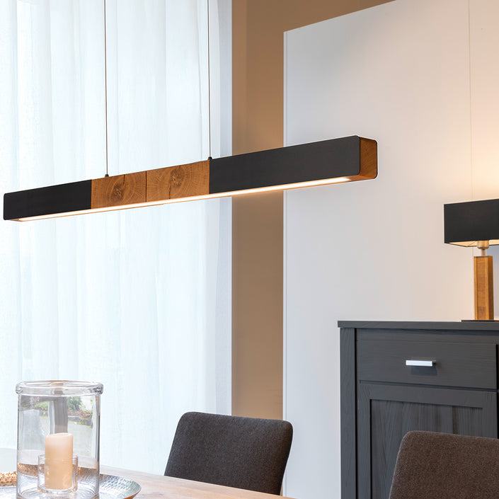 Balkenleuchte aus Asteiche geölt, Modell Lana del nero, 1300mm, Kopfholz, schwarze Applikationen, Dimm to warm per Tastdimmung, Milieubild, Leuchte hängt über Esstisch