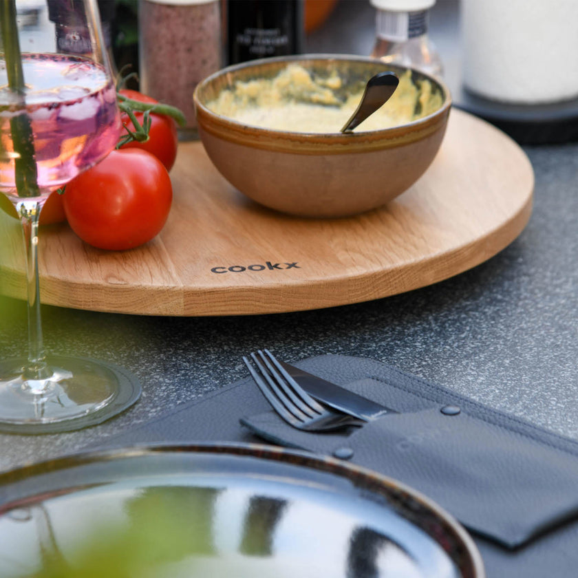 Drehteller aus Eichenholz Natur, Größe XL, 75cm Durchmesser, rund, COOKX Logo eingraviert, Milieubild im Garten, Teller mit Tomaten und Dip steht auf Tisch