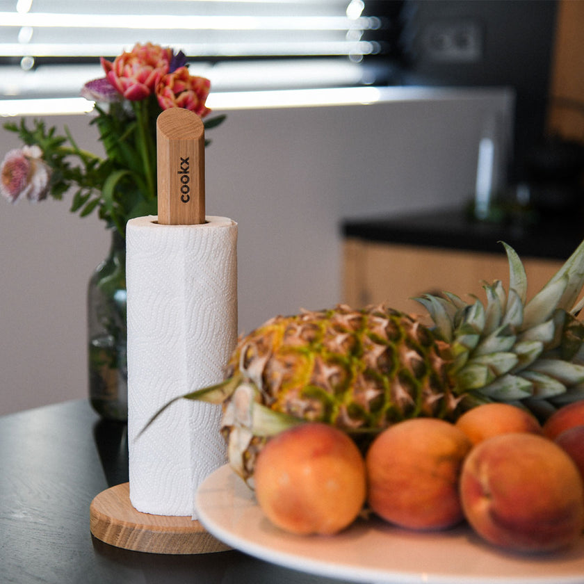 Küchenrollenhalter aus Eichenholz Natur, runde Platte unten ca. 15cm Durchmesser, Stab ca. 35cm hoch, Milieubild in Küche, Halter mit Küchenrolle zwischen Obst