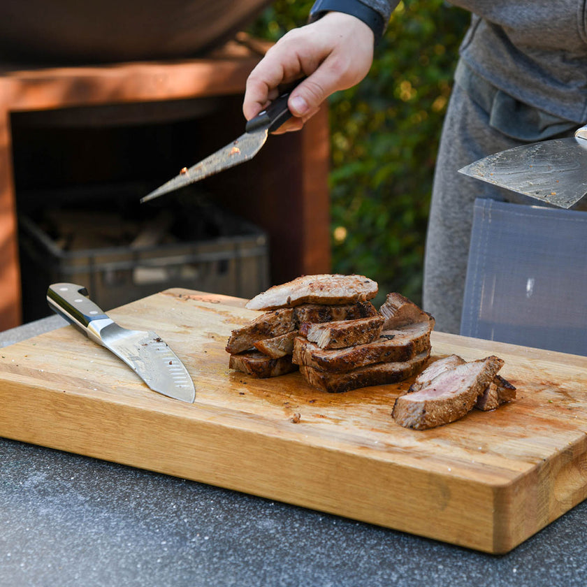 Hackbrett aus Eichenholz Natur, Größe S, COOKX Logo unten rechts eingraviert, Milieubild im Garten, gegrilltes Fleisch auf Brett geschnitten 