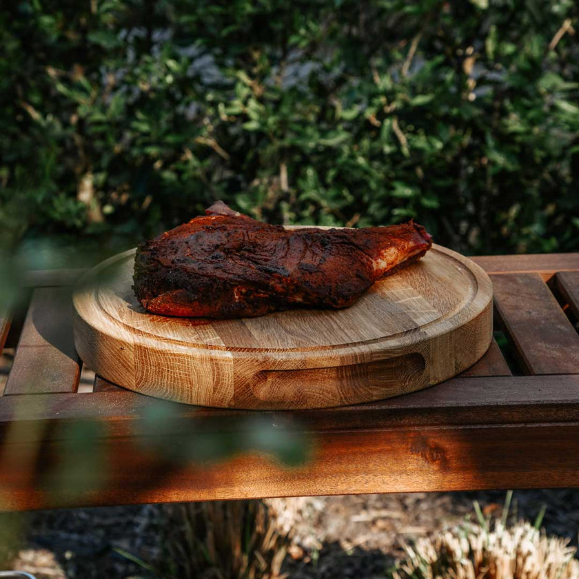 Hackbrett aus Holz Natur, Rund Größe S, 475cm Durchmesser, mit Griffeinkerbung, Milieubild im Garten, Steak liegt auf Brett