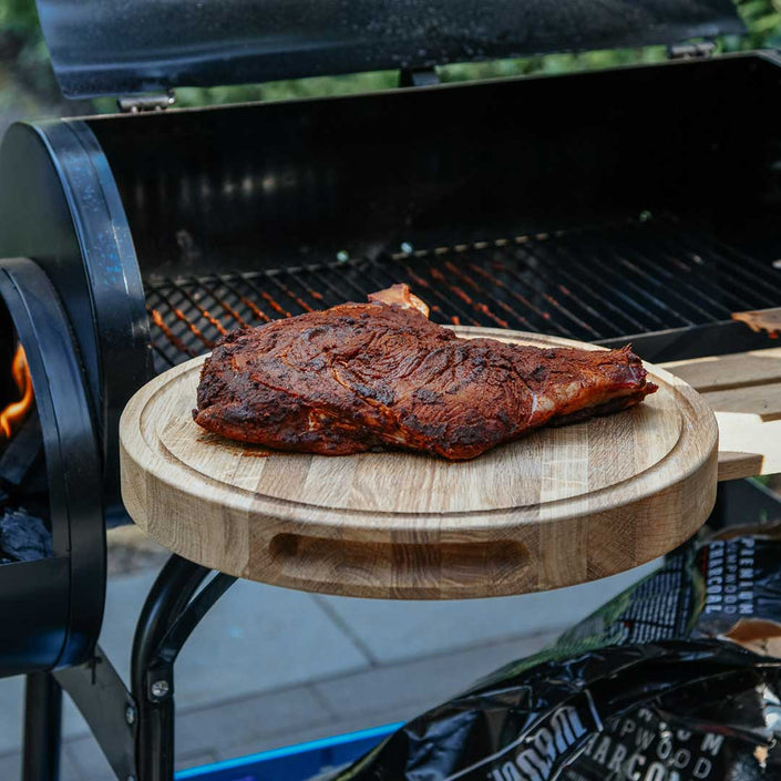 Hackbrett aus Holz Natur, Rund Größe S, 475cm Durchmesser, mit Griffeinkerbung, Milieubild im Garten, Steak liegt auf Brett