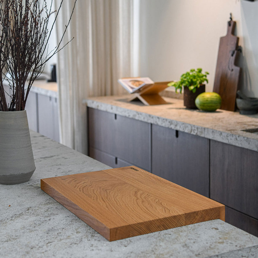 Hackbrett aus Eichenholz Natur, Antirutschkante, COOKX Logo unten rechts eingraviert, 50 x 34 x 3,5 cm, Milieubild in Küche, Seitenansicht schräg