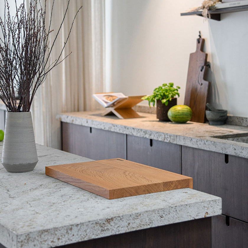 Hackbrett aus Eichenholz Natur, Antirutschkante, COOKX Logo unten rechts eingraviert, 50 x 34 x 3,5 cm, Milieubild in Küche, Seitenansicht schräg