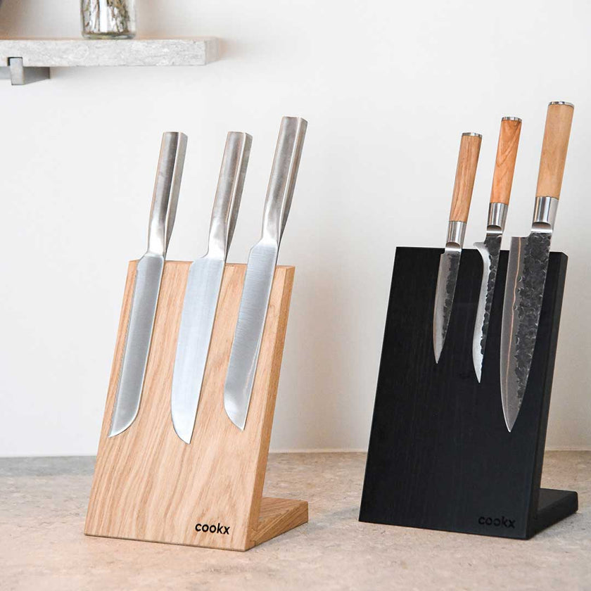 Messerblock aus Eichenholz schwarz und eins aus Eichenholz Natur, magnetisch, Messerblock schräg nach hinten geneigt, Milieubild in Küche, je drei Messer am Messerblock 