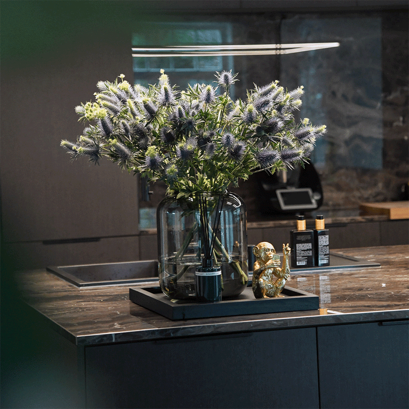 Serviertablett aus Eichenholz schwarz, 40cm x 40cm, Ränder etwas höher, Milieubild in Küche, Tablett steht auf Kücheninsel, Blumen und Deko stehen auf Serviertablett, Ansicht frontal