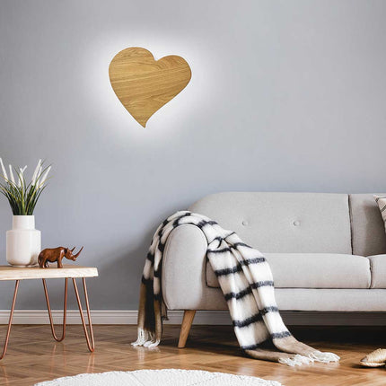 Wandleuchte aus Asteiche geölt, Modell HerzBlut Herz midi, LED, 445mm breit, 430mm hoch, Milieubild im Wohnzimmer, Leuchte hängt an Wand über Sofa