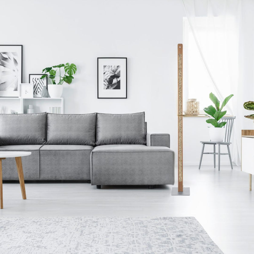 Stehleuchte aus Asteiche geölt und Almwiesenheuapplikation, Modell Karl H, Nickel Details, Dimm-to-warm-Funktion, Milieubild im Wohnzimmer, Leuchte steht neben Sofa