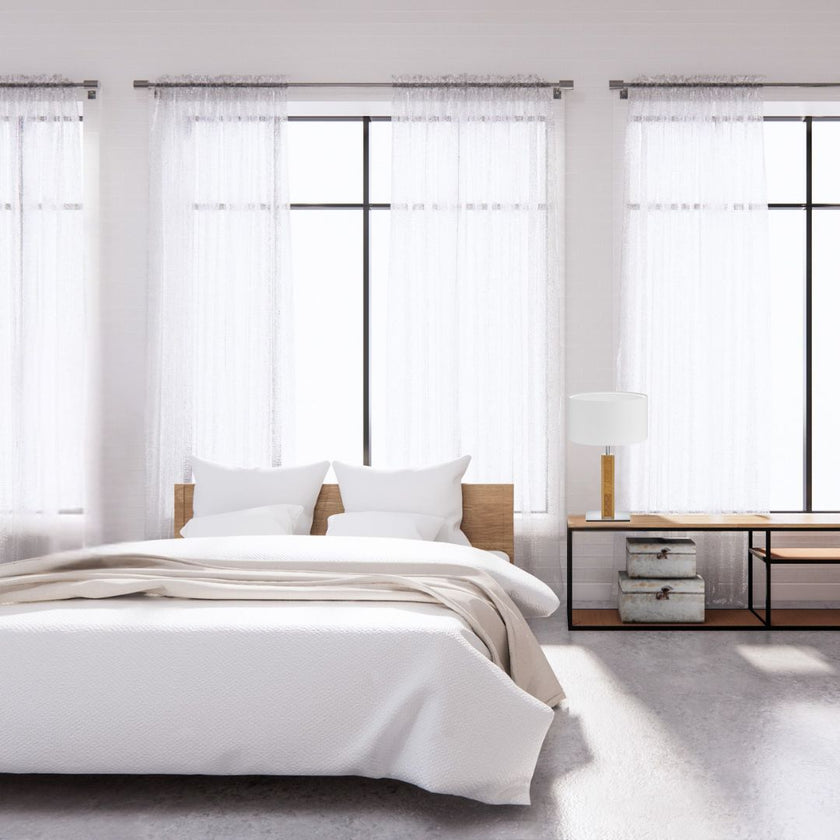 Hockerleuchte aus Asteiche geölt und Kopfholz, Modell Karl K, Nickel Applikationen, weißer Schirm, Milieubild im Schlafzimmer, Leuchte steht auf Nachttisch neben Bett