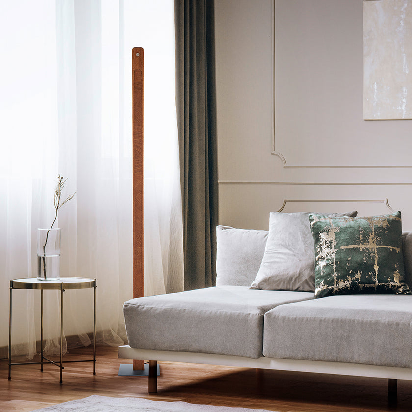 Stehleuchte aus Asteiche geölt und Kopfholz, Modell Karl K, Nickel Applikationen, Dimm-to-warm-Funktion, Milieubild im Wohnzimmer, Leuchte steht neben Sofa