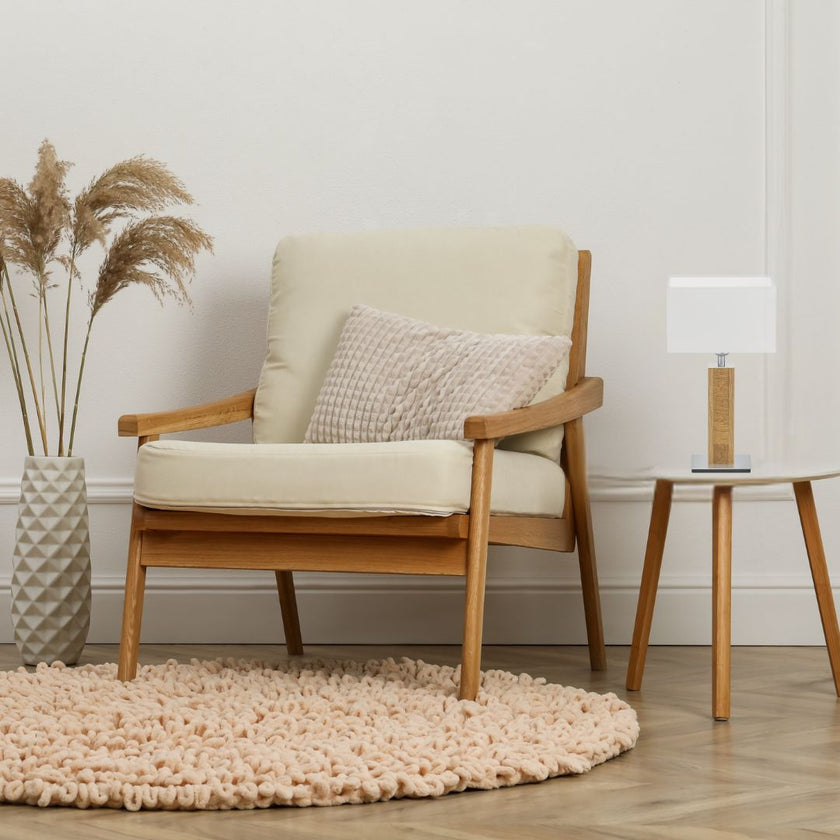 Tischleuchte aus Asteiche geölt und Kopfholz, Modell Karl K, weißer rechteckiger Schirm, Nickel Applikationen, Milieubild im Wohnzimmer, Leuchte steht auf Beistelltisch neben Sessel