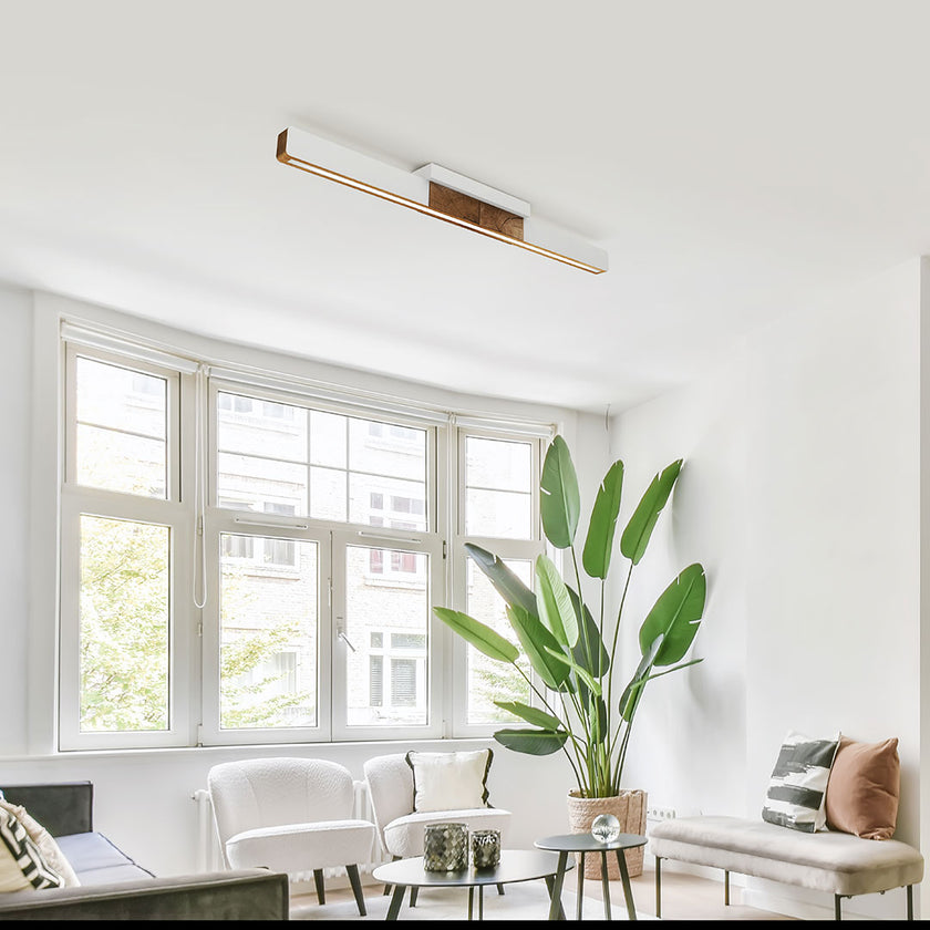 Deckenleuchte aus Asteiche geölt, Modell Lana del bianco, 1000mm, Kopfholz, weiße Applikationen, LED, Klick & Dimm, Milieubild im Wohnzimmer, Leuchte hängt an Decke über Sofa und Sessel 