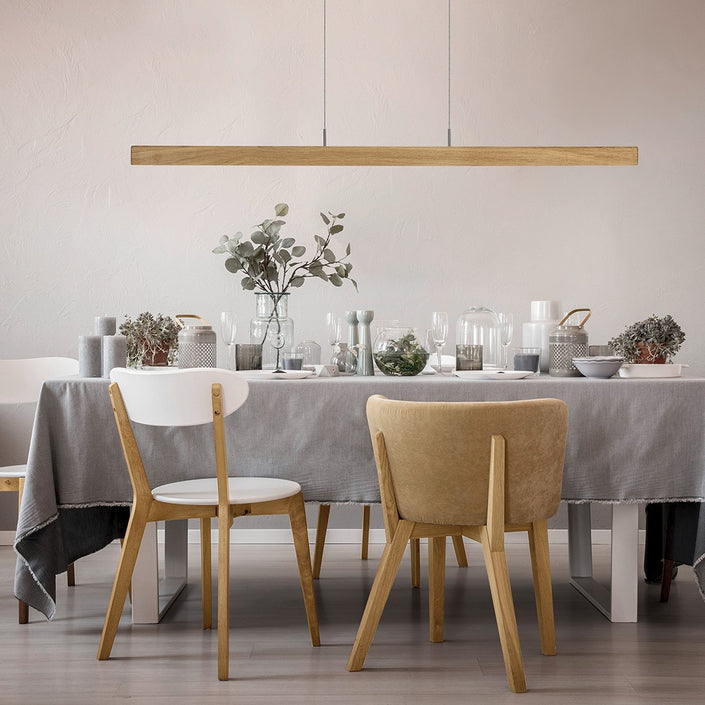 Balkenleuchte aus Asteiche geölt, Modell Leonora, Rollizug, 1210mm, LED Up & Down, Dimm-to-warm-Funktion, Milieubild, Leuchte hängt über Esstisch