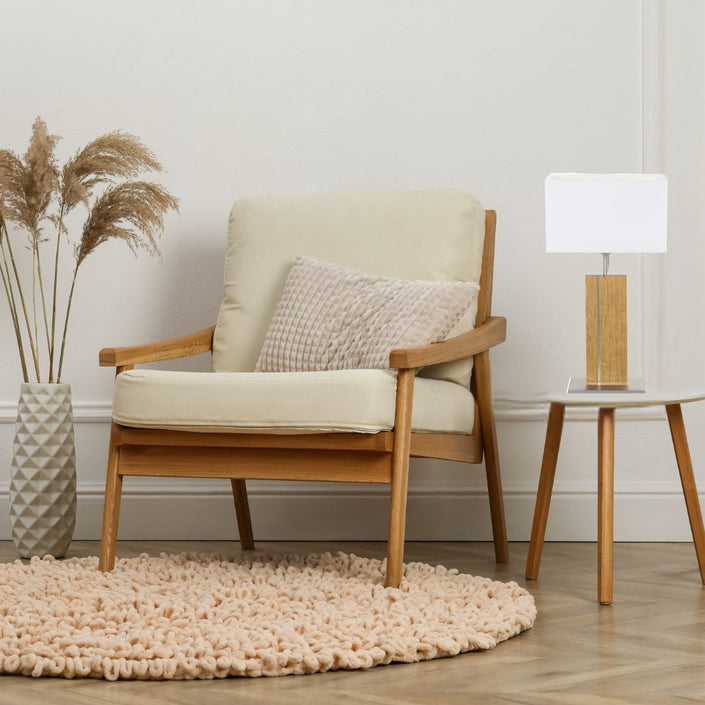 Hockerleuchte aus Asteiche geölt, Modell Miss Hilton, weißer eckiger Schirm, Metall Details Nickel matt gebürstet, Milieubild im Wohnzimmer, Leuchte steht auf Beistelltisch neben Sessel