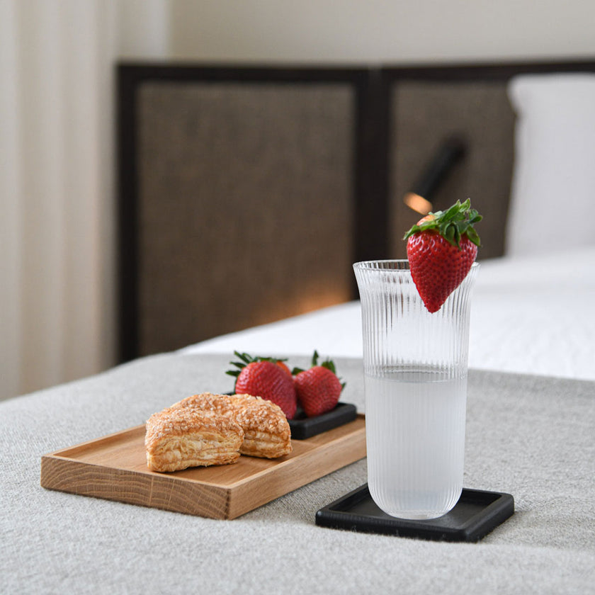 Kerzentablett aus Eichenholz Natur,  28 x 14 x 2,3 cm, Milieubild in Küche, auf Tablett liegen Gebäck und Früchte, rechts daneben steht ein Glas Wasser 