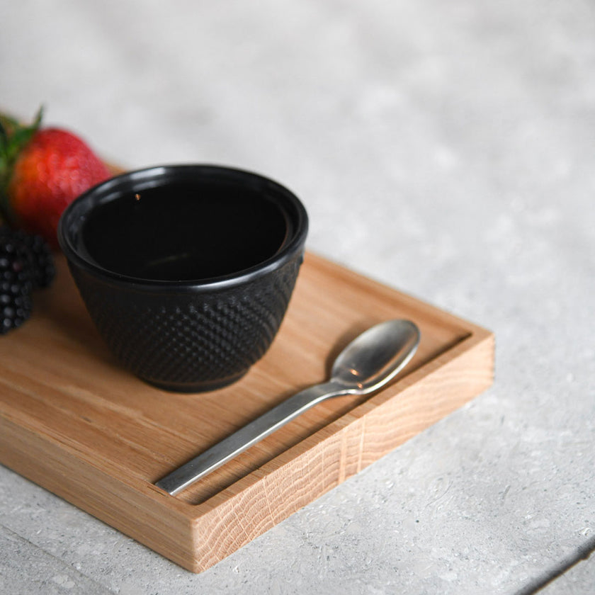 Kerzentablett aus Eichenholz schwarz,  28 x 14 x 2,3 cm, Milieubild in Küche, auf Tablett liegen Früchte, Löffel und kleine schwarze Tasse  